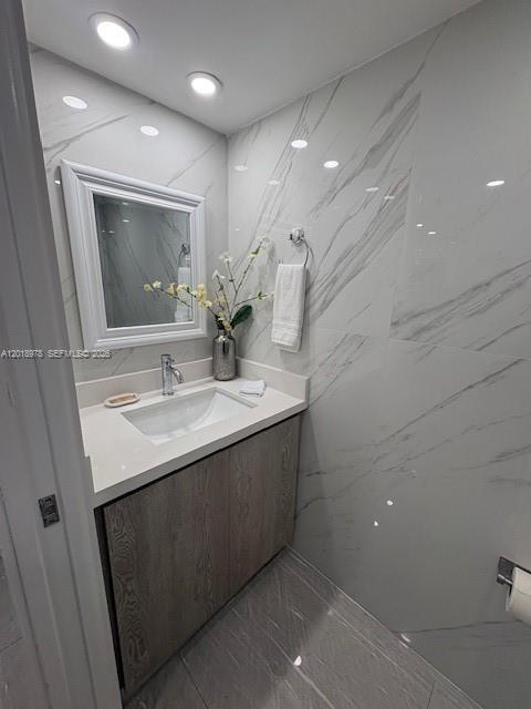 A modern bathroom features a wood vanity, white quartz countertop, and white marble-patterned wall tiles — 1717 N Bayshore Dr # 1542, Miami FL 33132, MIAMI, FL