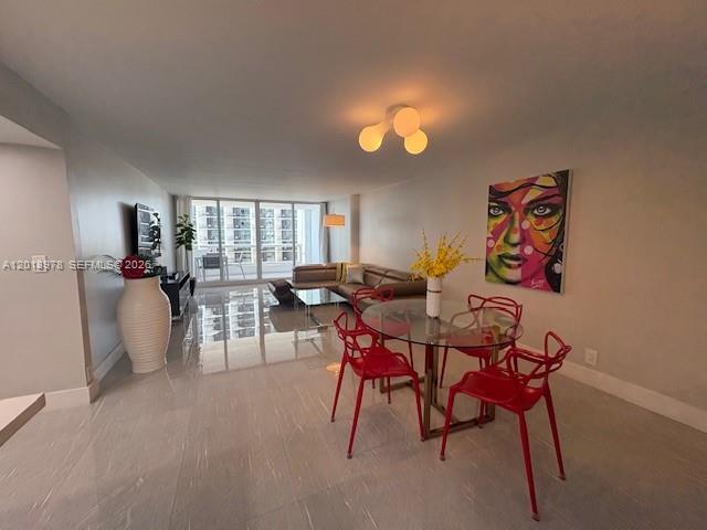 A dining area with a glass table and red chairs sits near a living room — 1717 N Bayshore Dr # 1542, Miami FL 33132, MIAMI, FL