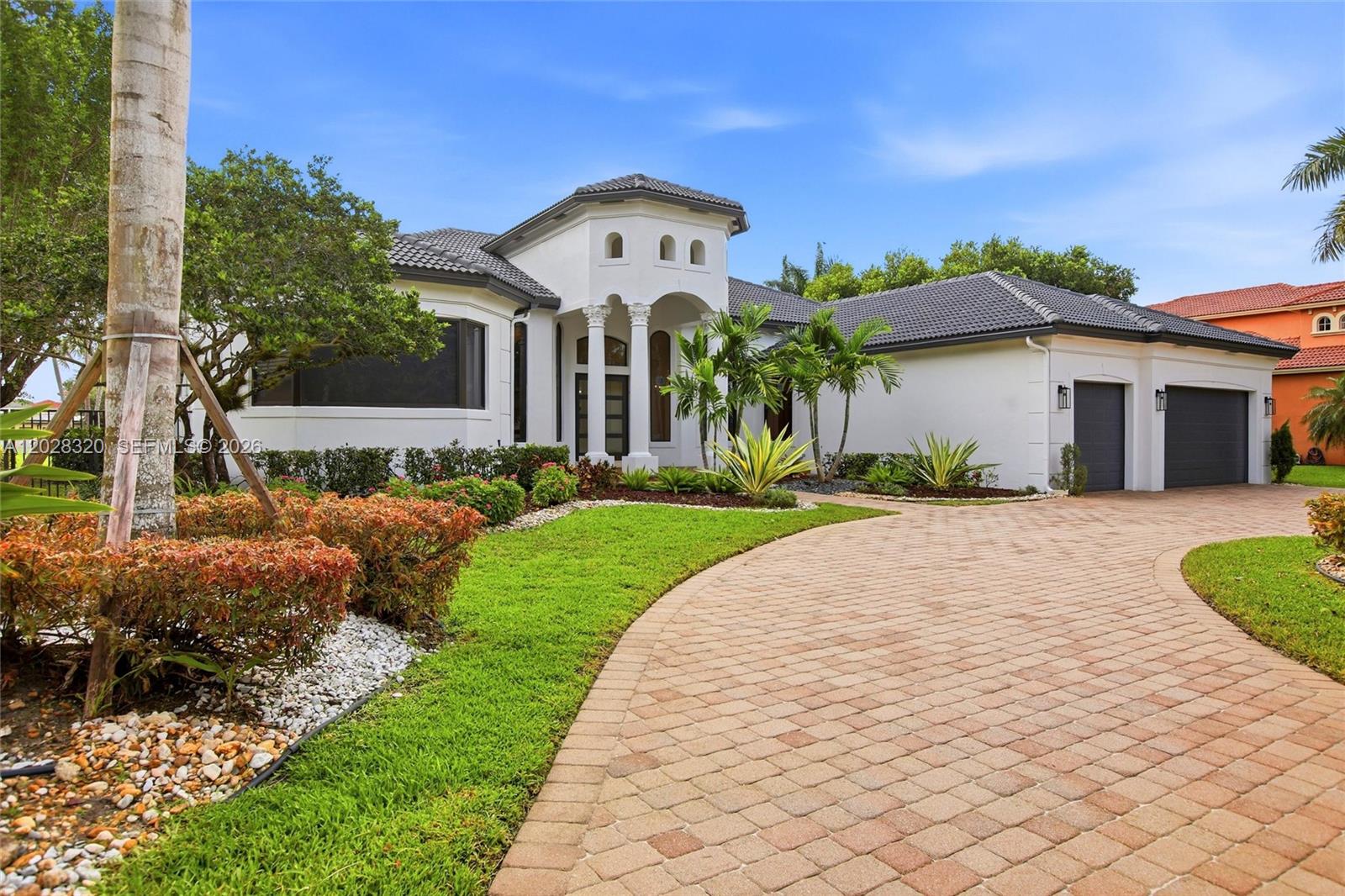 A white house with a tiled roof, a paved driveway, and a landscaped front yard — 3250 W Stonebrook Cir, Davie FL 33330, DAVIE, FL