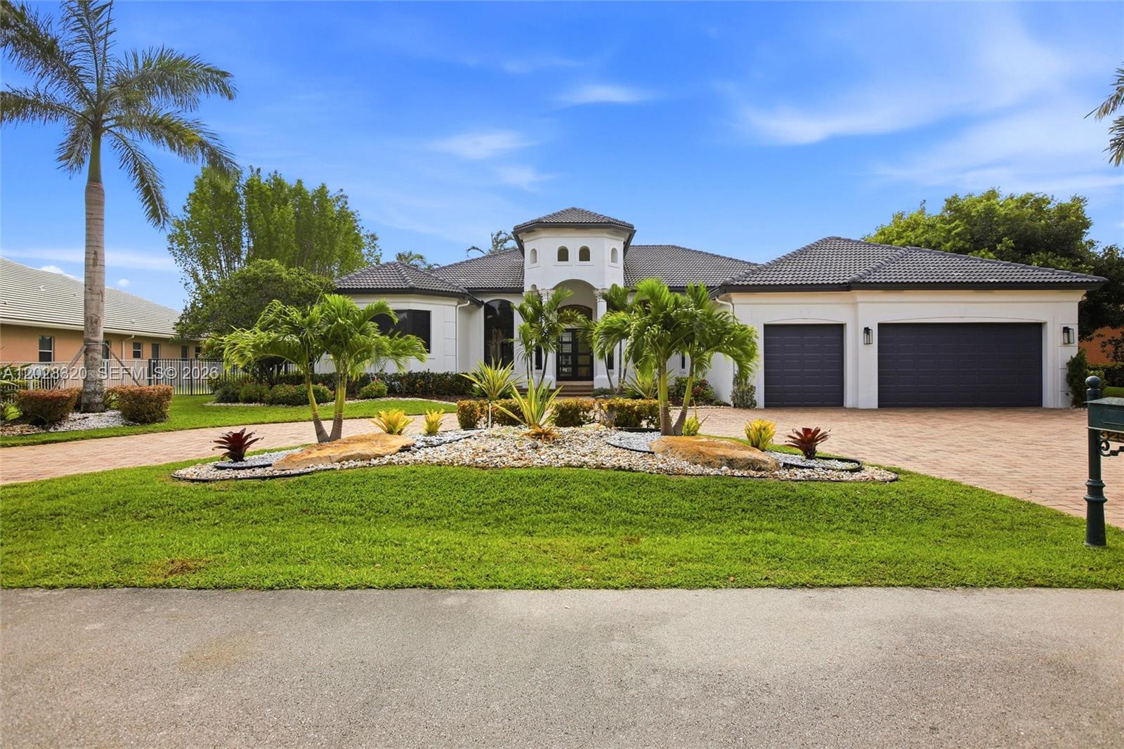 A single-story white house with a dark tiled roof and a circular driveway — 3250 W Stonebrook Cir, Davie FL 33330, DAVIE, FL