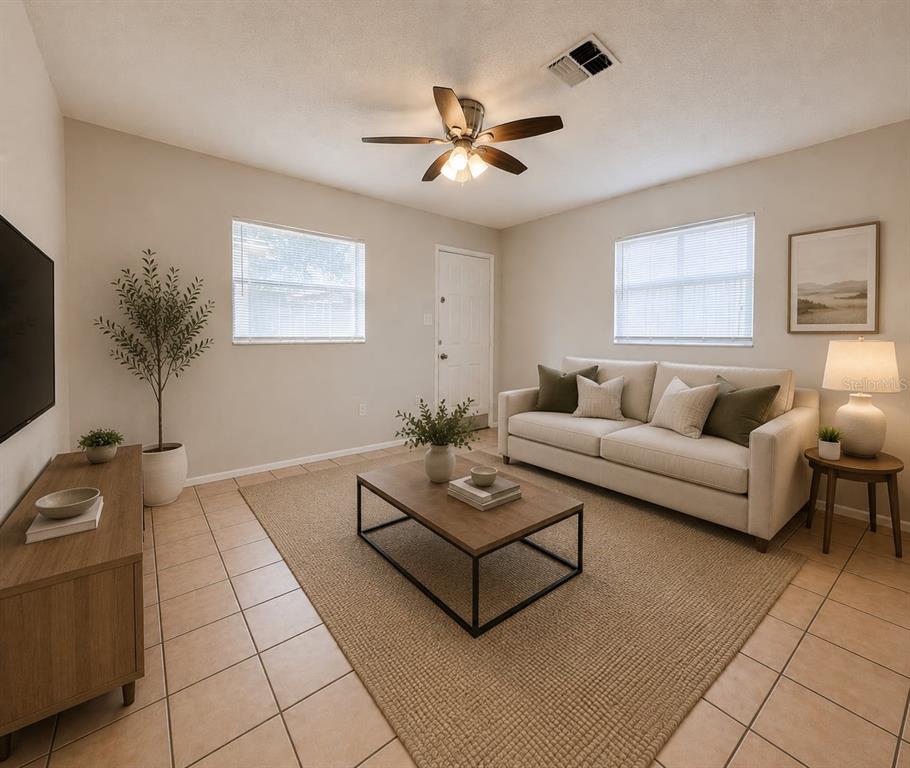 A living room features a beige sofa, a wooden coffee table, and tile flooring — 5723 SILVER SPUR DRIVE, HOLIDAY, FL
