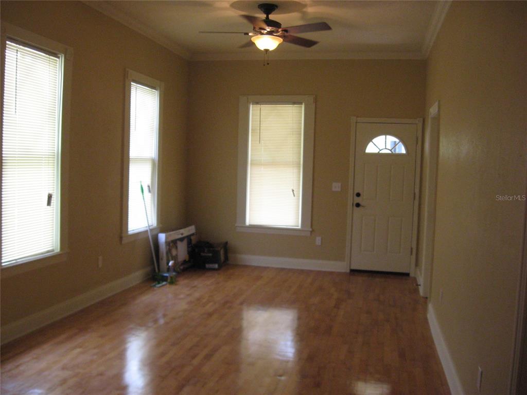 An empty room features hardwood floors, three windows with blinds, and a ceiling fan — 1506 N 15TH STREET, TAMPA, FL