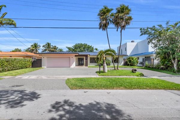 A single-story house with a flat roof, a two-car garage, and palm trees in front — 2025 Arch Creek Dr, North Miami FL 33181, NORTH MIAMI, FL