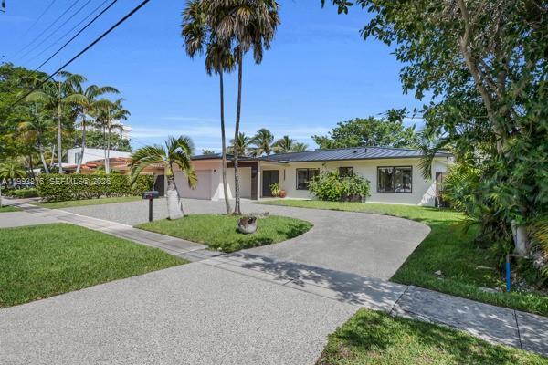 A single-story house with a large concrete driveway and palm trees in the front yard — 2025 Arch Creek Dr, North Miami FL 33181, NORTH MIAMI, FL