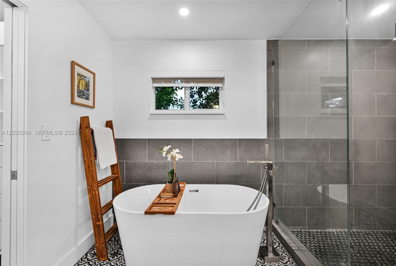 A bathroom features a freestanding white tub, a glass-enclosed shower, and patterned floor tiles — 150 NE 50th Ter, Miami FL 33137, MIAMI, FL