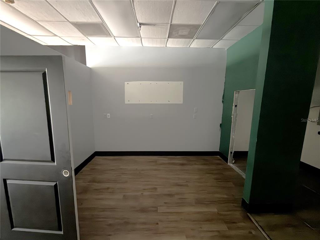 An interior room features light gray walls, wood-look flooring, a drop ceiling, and a doorway — 226 ST. JOE PLAZA DRIVE, PALM COAST, FL