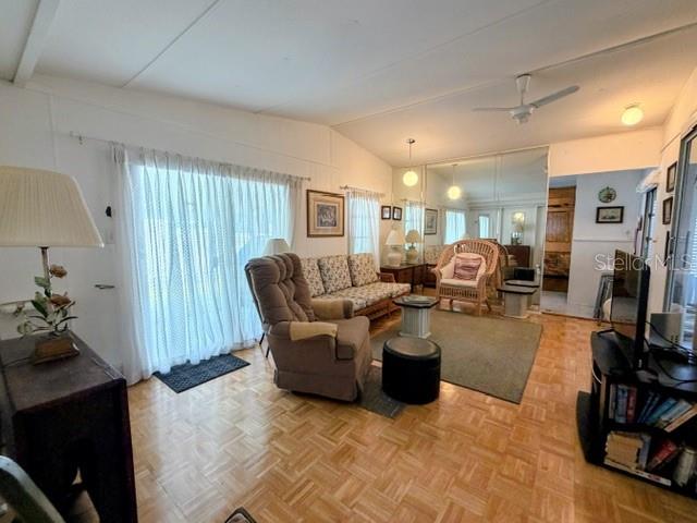 A living room features a recliner, sofa, sliding glass doors, and light wood parquet flooring — 857 S GREEN CIRCLE, VENICE, FL