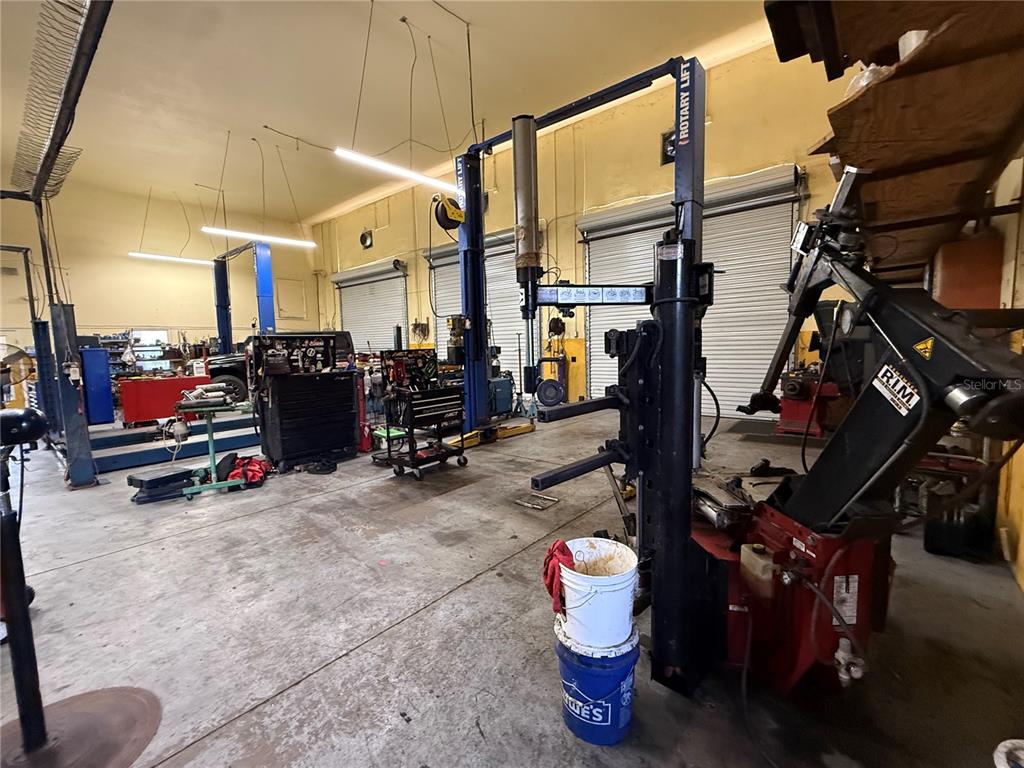 An automotive repair shop featuring multiple vehicle lifts, workbenches, and tire changing equipment — 23371 HARBORVIEW ROAD UNIT A, PUNTA GORDA, FL