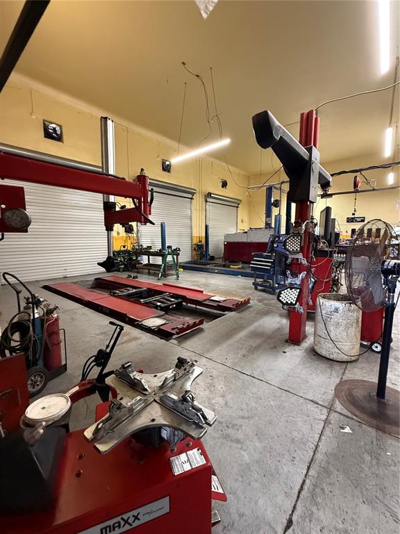 An automotive repair shop features a vehicle lift, tire changing equipment, and a pedestal fan — 23371 HARBORVIEW ROAD UNIT A, PUNTA GORDA, FL