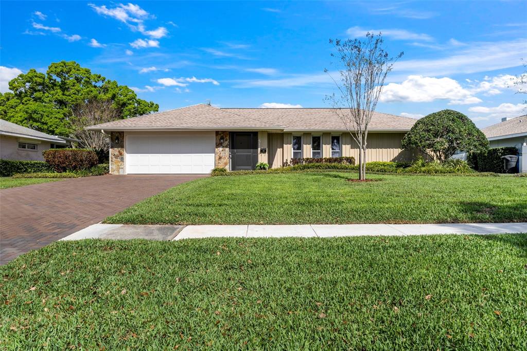 A swimming pool with a screened enclosure and paver patio overlooking a lake — 511 RIVIERA BAY DRIVE NE, ST PETERSBURG, FL