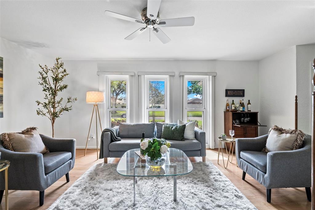 A dining room with a dark wood table, upholstered chairs, and an adjacent living area — 511 RIVIERA BAY DRIVE NE, ST PETERSBURG, FL
