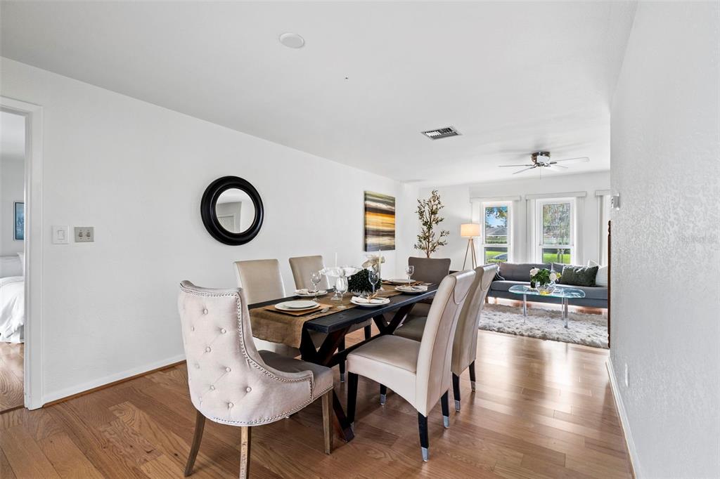 A living room features a black sofa, a patterned rug, and a wood-paneled accent wall — 511 RIVIERA BAY DRIVE NE, ST PETERSBURG, FL