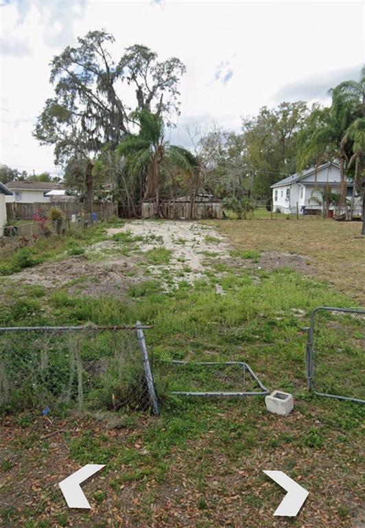 A vacant, grassy residential lot with a chain-link fence and mature trees in the background — 3788 SUMMER HAVEN LANE, APOPKA, FL