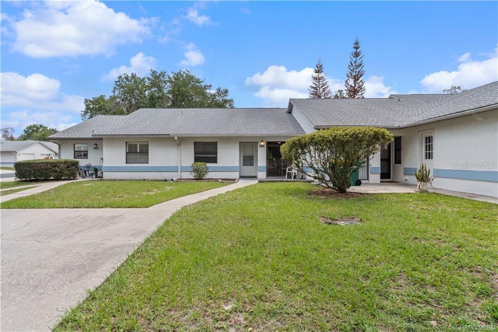 A single-story residential building with a gray roof, white walls, and a concrete walkway — 1304 SIESTA TERRACE UNIT 1304, INVERNESS, FL