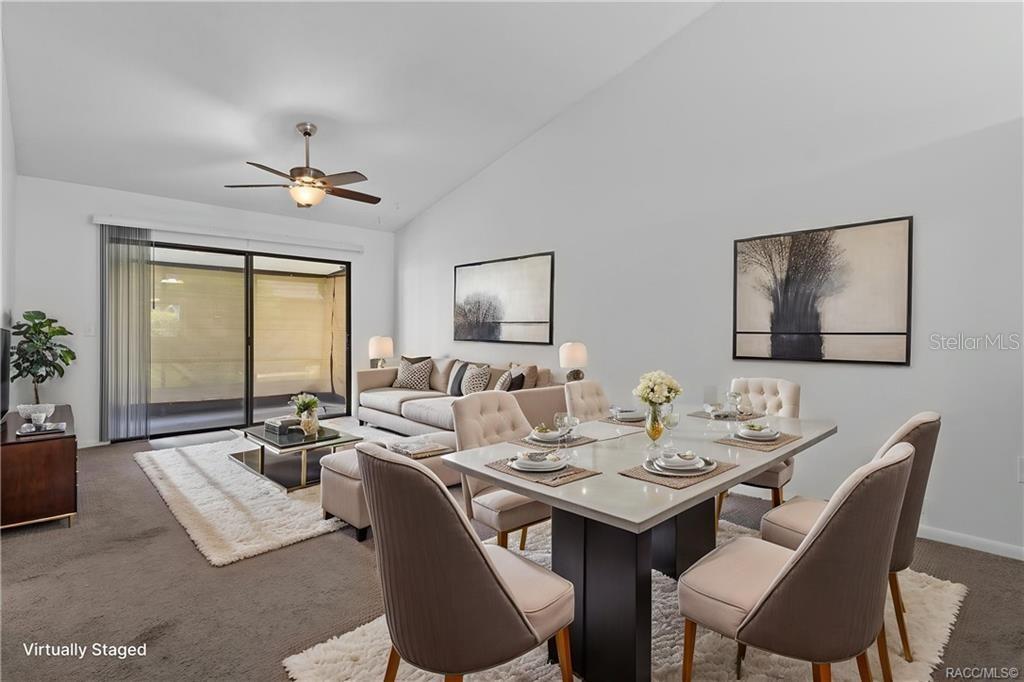 A living and dining room area features neutral furniture, a ceiling fan, and sliding doors — 1304 SIESTA TERRACE UNIT 1304, INVERNESS, FL