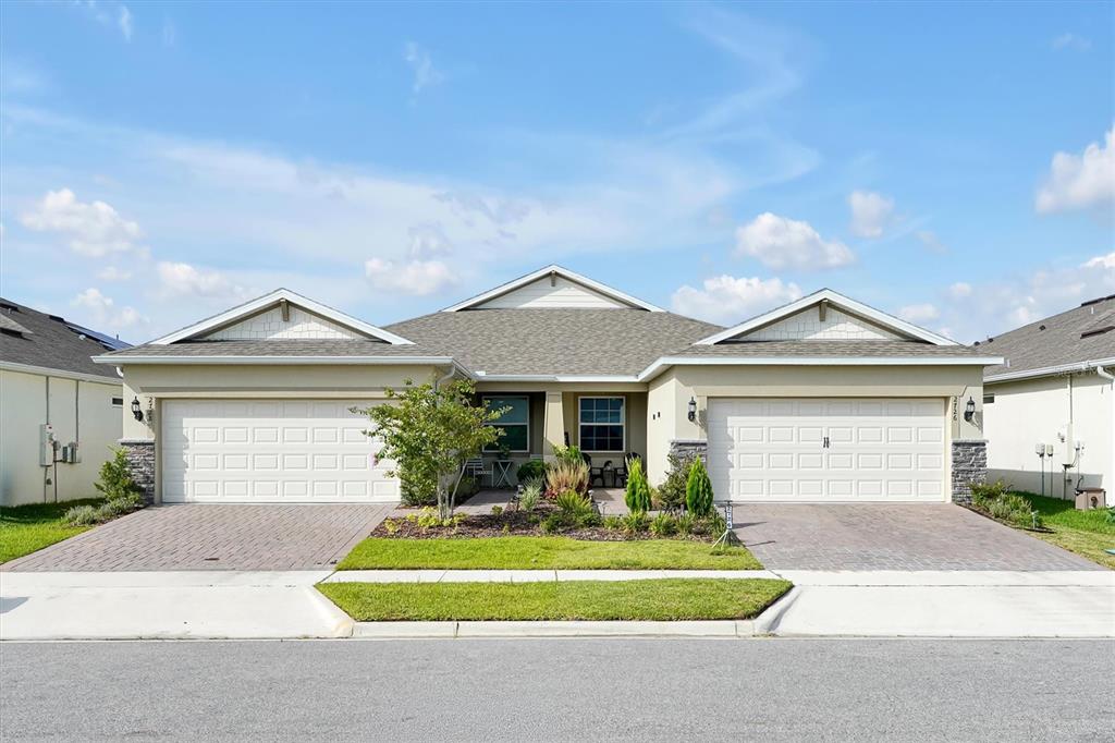 A duplex house with two garages, paved driveways, and a shared front entrance — 2726 SUMMER RETREAT LANE, KISSIMMEE, FL