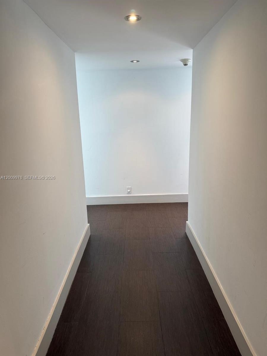 A narrow hallway features white walls, dark wood-look flooring, and two recessed ceiling lights — 150 Ocean Lane Dr # 6F, Key Biscayne FL 33149, KEY BISCAYNE, FL