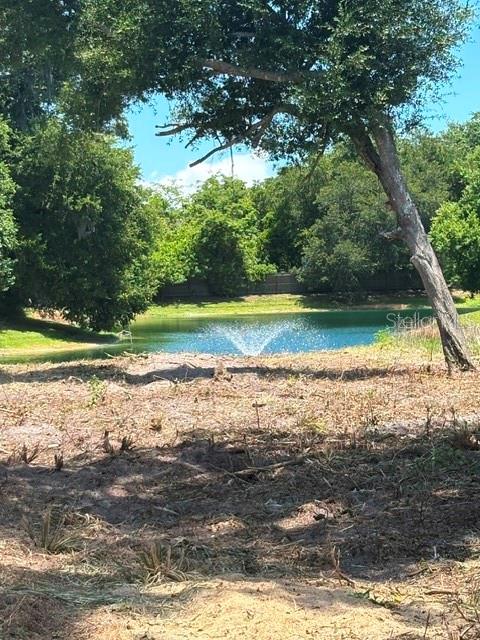 A view of a pond with a fountain, seen from a cleared, grassy lot — 1371 VINE STREET, DAYTONA BEACH, FL