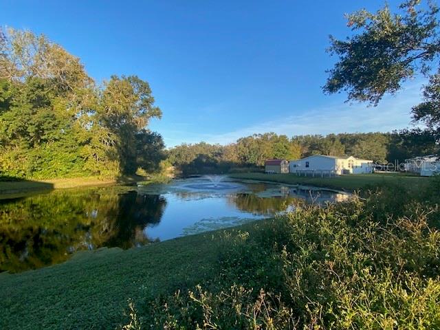 A pond with a fountain sits in front of a house and a small shed — 1371 VINE STREET, DAYTONA BEACH, FL
