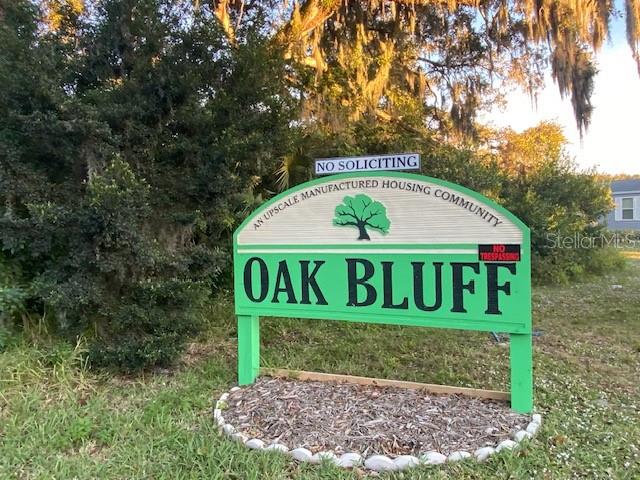 A green and white sign for Oak Bluff manufactured housing community stands outdoors — 1371 VINE STREET, DAYTONA BEACH, FL