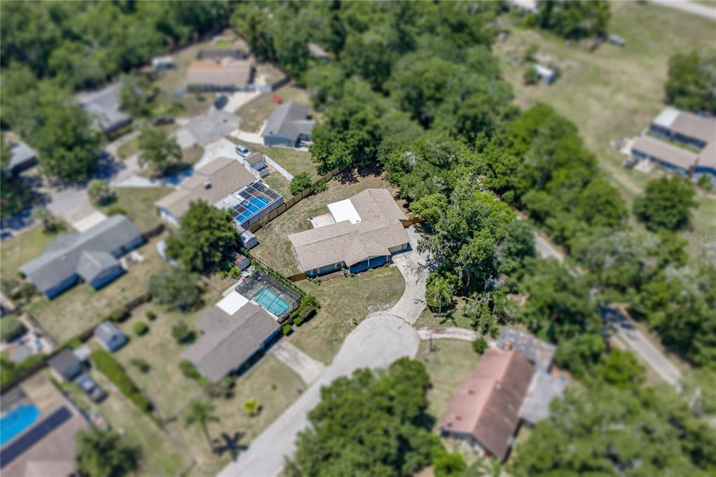 An aerial view shows a residential house with a shingled roof and a circular driveway — 37634 HIDDEN PARK COURT, DADE CITY, FL