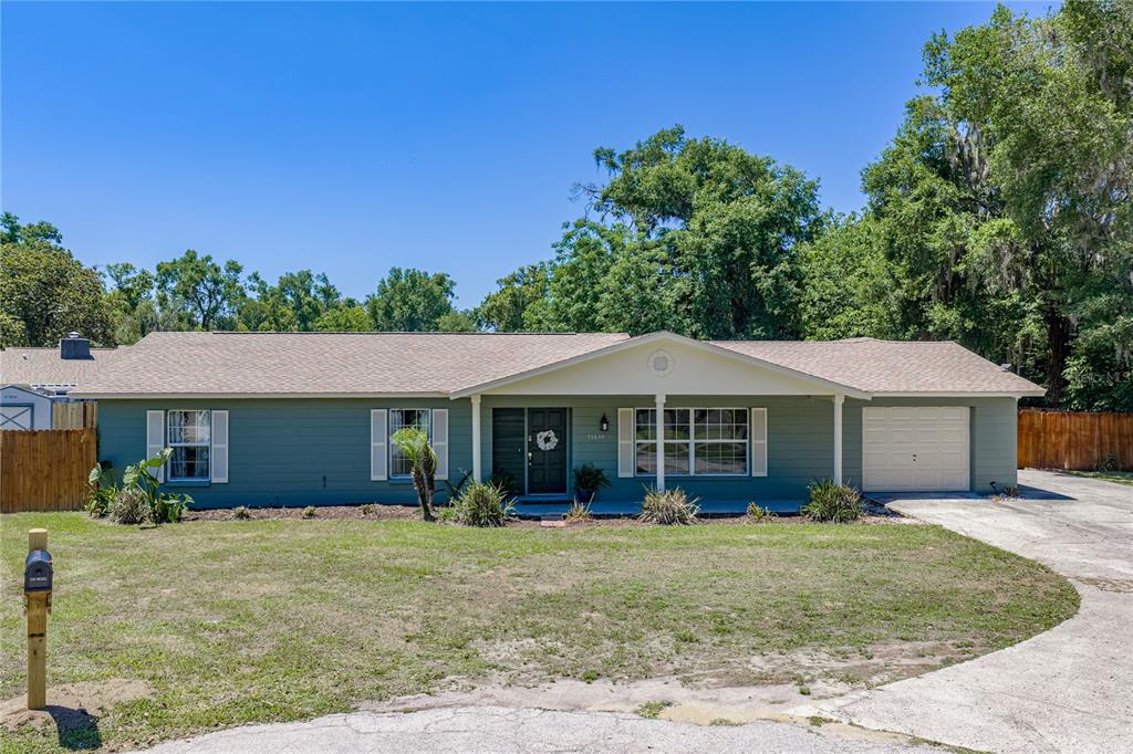 A single-story house with green siding, a shingled roof, and an attached garage — 37634 HIDDEN PARK COURT, DADE CITY, FL