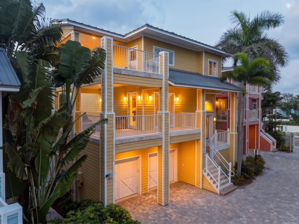 A three-story yellow house with multiple balconies, a paved driveway, and a garage — 2718 GULF BOULEVARD UNIT 2, INDIAN ROCKS BEACH, FL