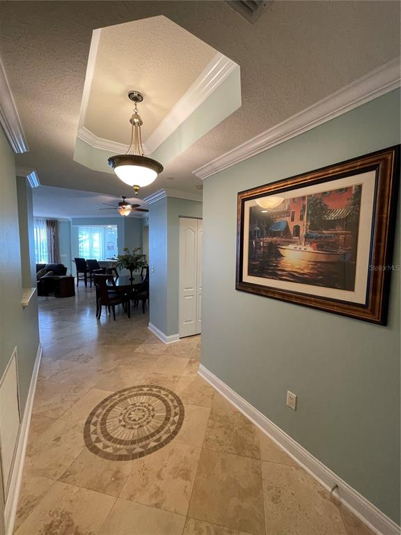 A foyer with tile flooring and a decorative medallion leads to a dining area — 521 MANDALAY AVENUE UNIT 309, CLEARWATER BEACH, FL