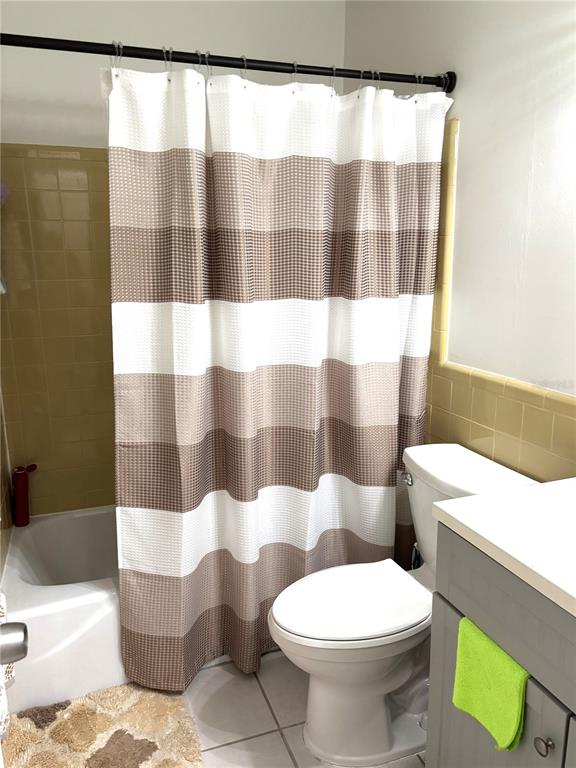 A bathroom features a shower with a brown and white curtain, a toilet, and a vanity — 2115 9TH AVENUE W UNIT 6B, BRADENTON, FL