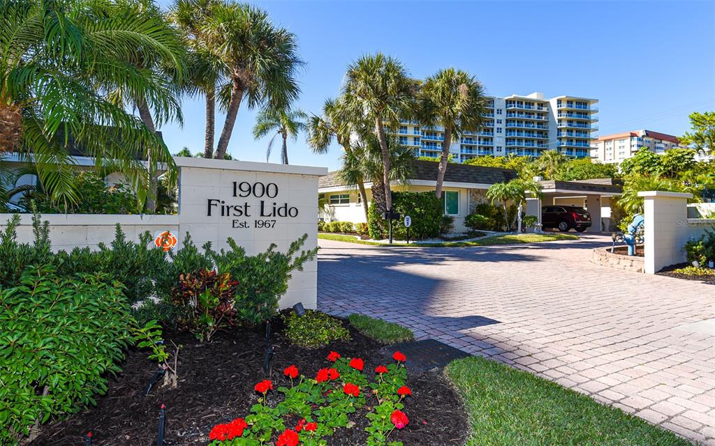 An aerial view of a beachfront condominium complex with a central pool and parking area — 1900 BENJAMIN FRANKLIN DRIVE UNIT V11, SARASOTA, FL