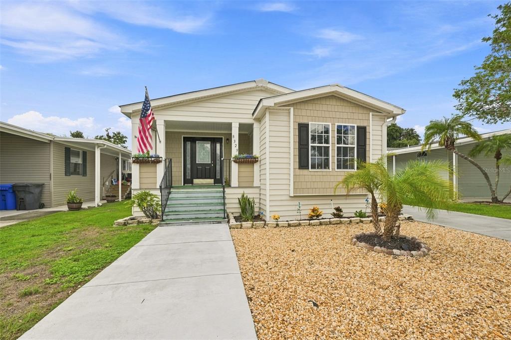 A single-story house with light siding, a front porch, and a gravel yard — 8329 FANTASIA PARK WAY, RIVERVIEW, FL