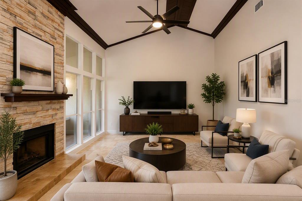 A living room features a stone fireplace, vaulted ceilings, a sectional sofa, and a television — 178 W SABAL PALM PLACE UNIT 178, LONGWOOD, FL