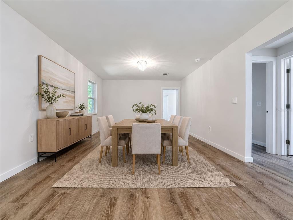 A dining room features a wooden table, six upholstered chairs, a sideboard, and wood-look flooring — 317 NE 13TH TERRACE, CRYSTAL RIVER, FL