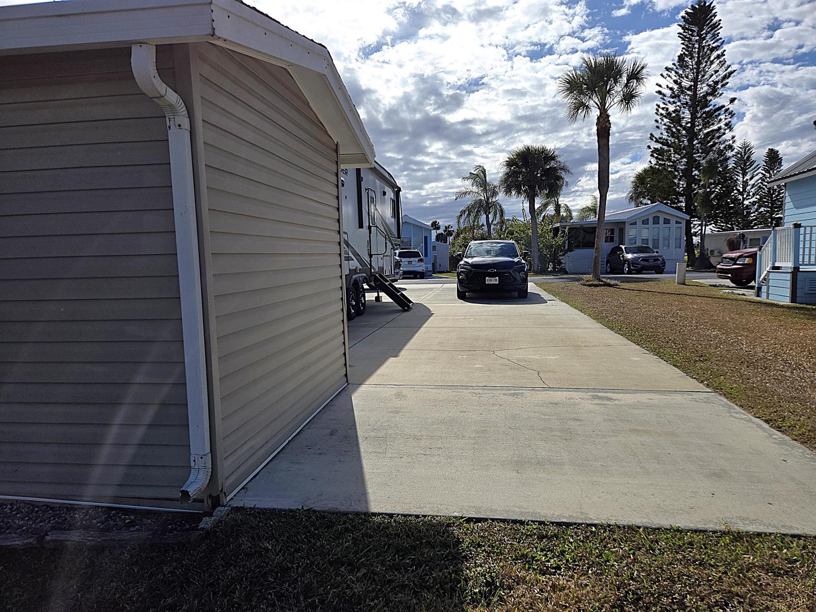 A concrete driveway leads to a parked SUV and a recreational vehicle beside a house — 14031 SE 126th Terrace, Okeechobee FL 34974, OKEECHOBEE, FL