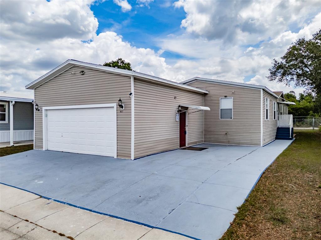 A beige house with a white garage door and a gray concrete driveway — 8471 FANTASIA PARK WAY, RIVERVIEW, FL