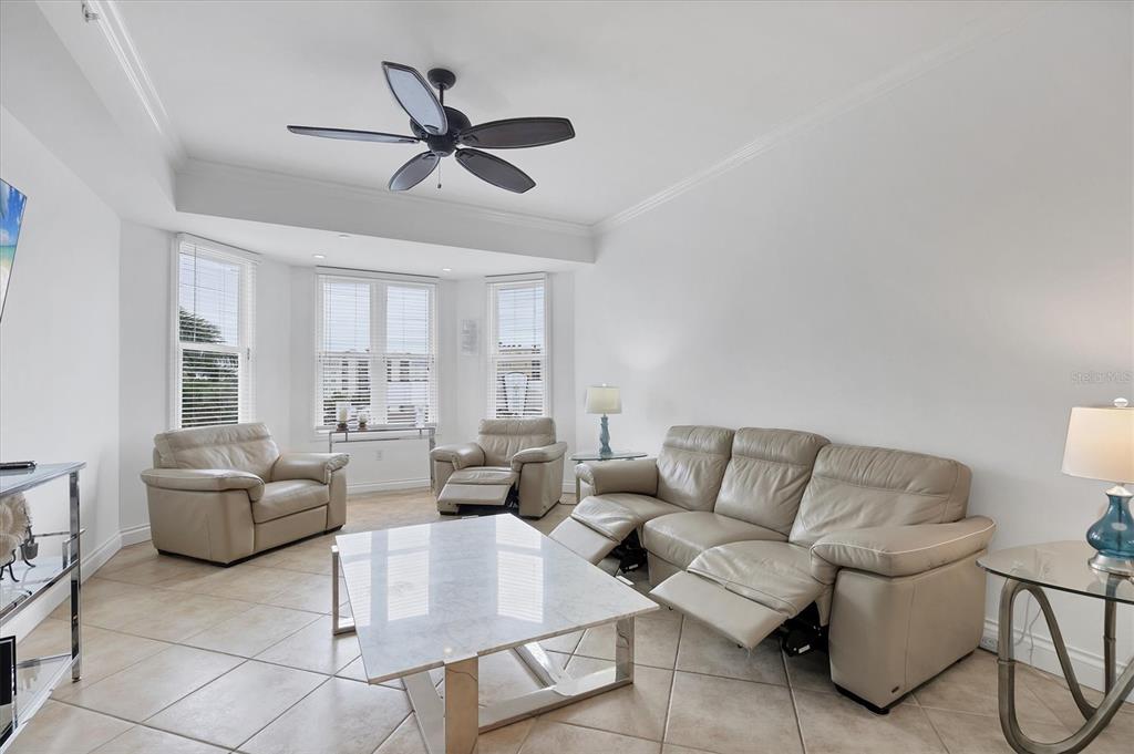 A living room features light-colored leather furniture, a marble coffee table, and tile flooring — 8111 LAKEWOOD MAIN STREET UNIT 304, LAKEWOOD RANCH, FL