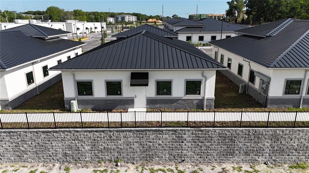 An aerial view shows several modern, single-story commercial buildings with dark metal roofs and white siding — 2775 OCOEE APOPKA ROAD UNIT 11, APOPKA, FL