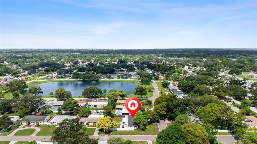 An aerial view shows a residential neighborhood with a lake and a marked house — 4300 28TH AVENUE N, ST PETERSBURG, FL