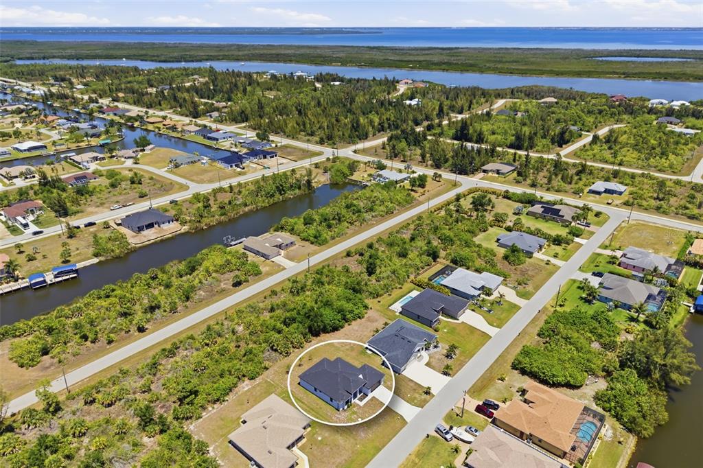 An aerial view shows a residential neighborhood with a circled house near a canal — 15725 AUTRY CIRCLE, PORT CHARLOTTE, FL