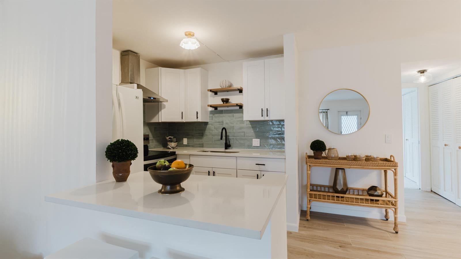 A kitchen features white cabinets, a light blue tile backsplash, and a white countertop island — 272 Preston G Way, Boca Raton FL 33434, BOCA RATON, FL