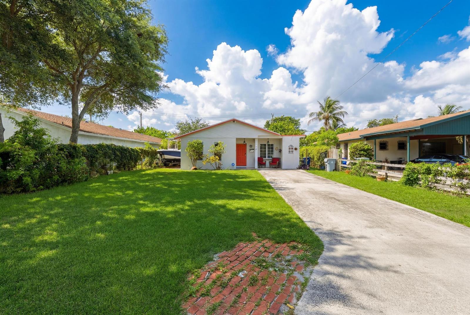 A single-story house with a bright orange front door and a concrete driveway — 224 NW 9th Street, Pompano Beach FL 33060, POMPANO BEACH, FL