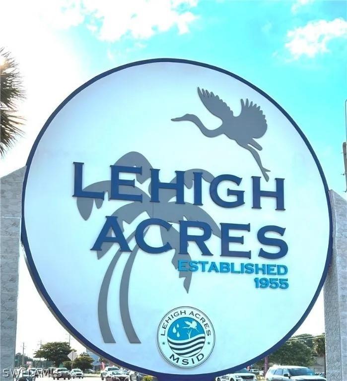A circular sign for Lehigh Acres stands outdoors against a blue sky — 553 Eisenhower Boulevard, Lehigh Acres FL 33974, LEHIGH ACRES, FL