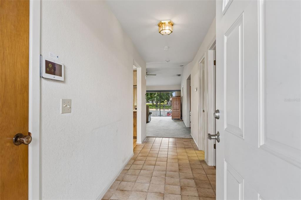 A tiled entryway leads into a living area with a sliding glass door to the outside — 7920 RADCLIFFE CIRCLE, PORT RICHEY, FL