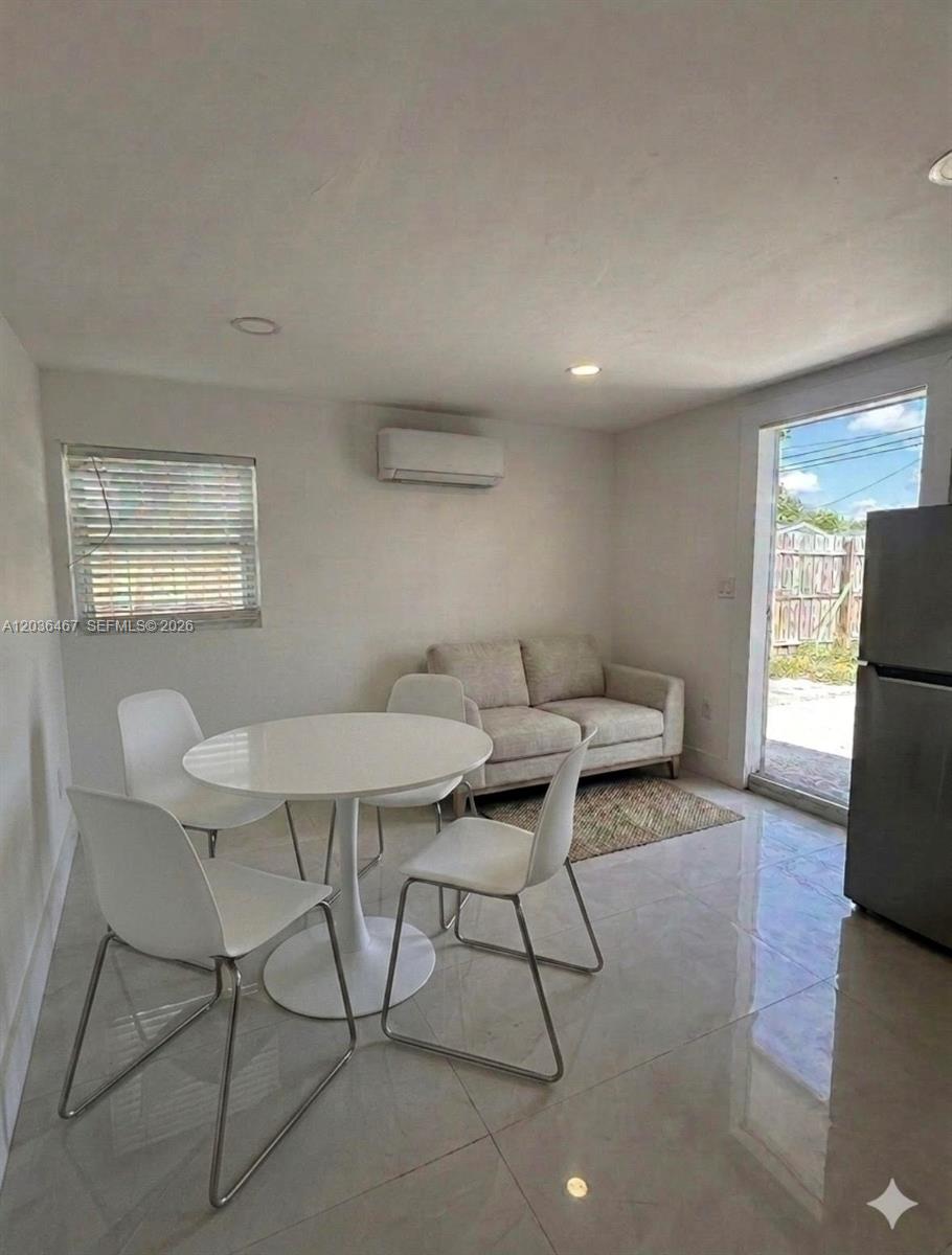 A small dining area with a white table and chairs sits next to a sofa — 1321 NE 212th Ter # 2, Miami FL 33179, MIAMI, FL