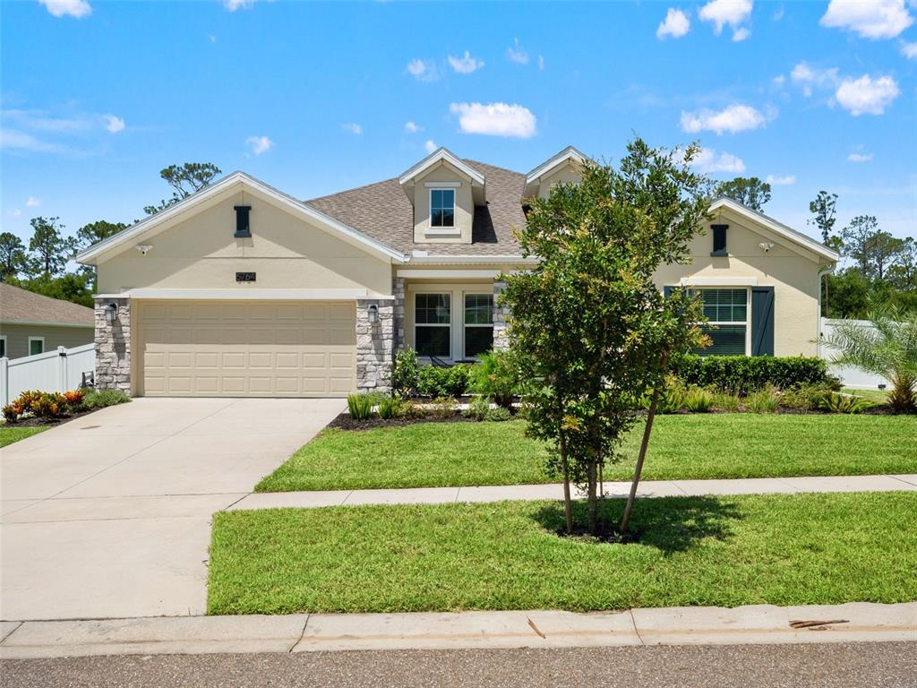 A single-story suburban house features a two-car garage, stone accents, and a front lawn — 5764 ALENLON WAY, MOUNT DORA, FL