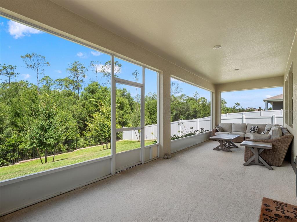 A screened-in patio features a concrete floor, outdoor furniture, and a view of the yard — 5764 ALENLON WAY, MOUNT DORA, FL
