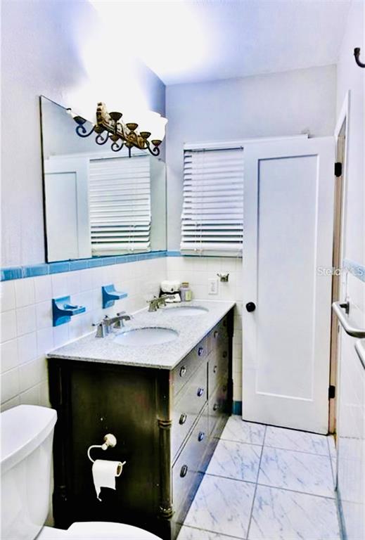 A single-story house with a bright red front door and a covered front porch — 3925 W BAY VIEW AVENUE, TAMPA, FL