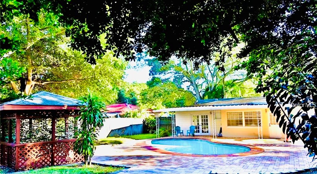 A kitchen features white cabinets, granite countertops, a stainless steel sink, and a dishwasher — 3925 W BAY VIEW AVENUE, TAMPA, FL