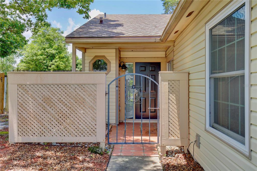 A front entrance features a gated courtyard with a lattice privacy fence and a dark door — 904 NORFOLK COURT, LONGWOOD, FL