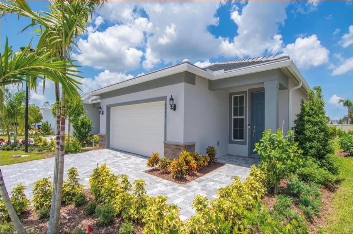 A single-story house with a gray exterior, a two-car garage, and a paved driveway — 4520 Jolly Roger Manor, Vero Beach FL 32967, VERO BEACH, FL